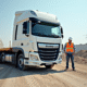 Camion plateau blanc sur un chantier avec ouvriers et matériaux