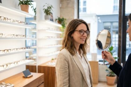 Une femme essaie une nouvelle monture de lunettes dans une opticienne moderne à Paris