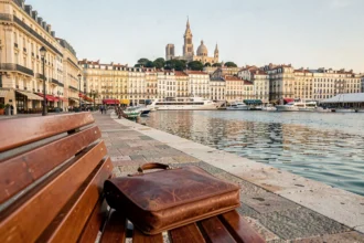 Vue panoramique du Vieux-Port de Marseille avec une mallette d'avocat posée sur un banc, symbolisant les meilleurs cabinets d'avocats de la ville